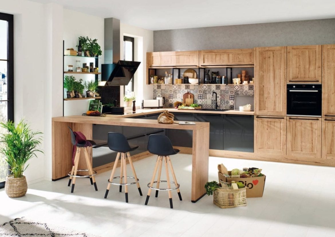 Une Cuisine en U moderne avec îlot en bois clair et placards bicolores.