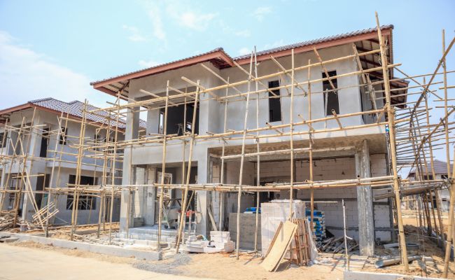 Façade de deux étages en cours de construction maison avec des échafaudages en bambou.