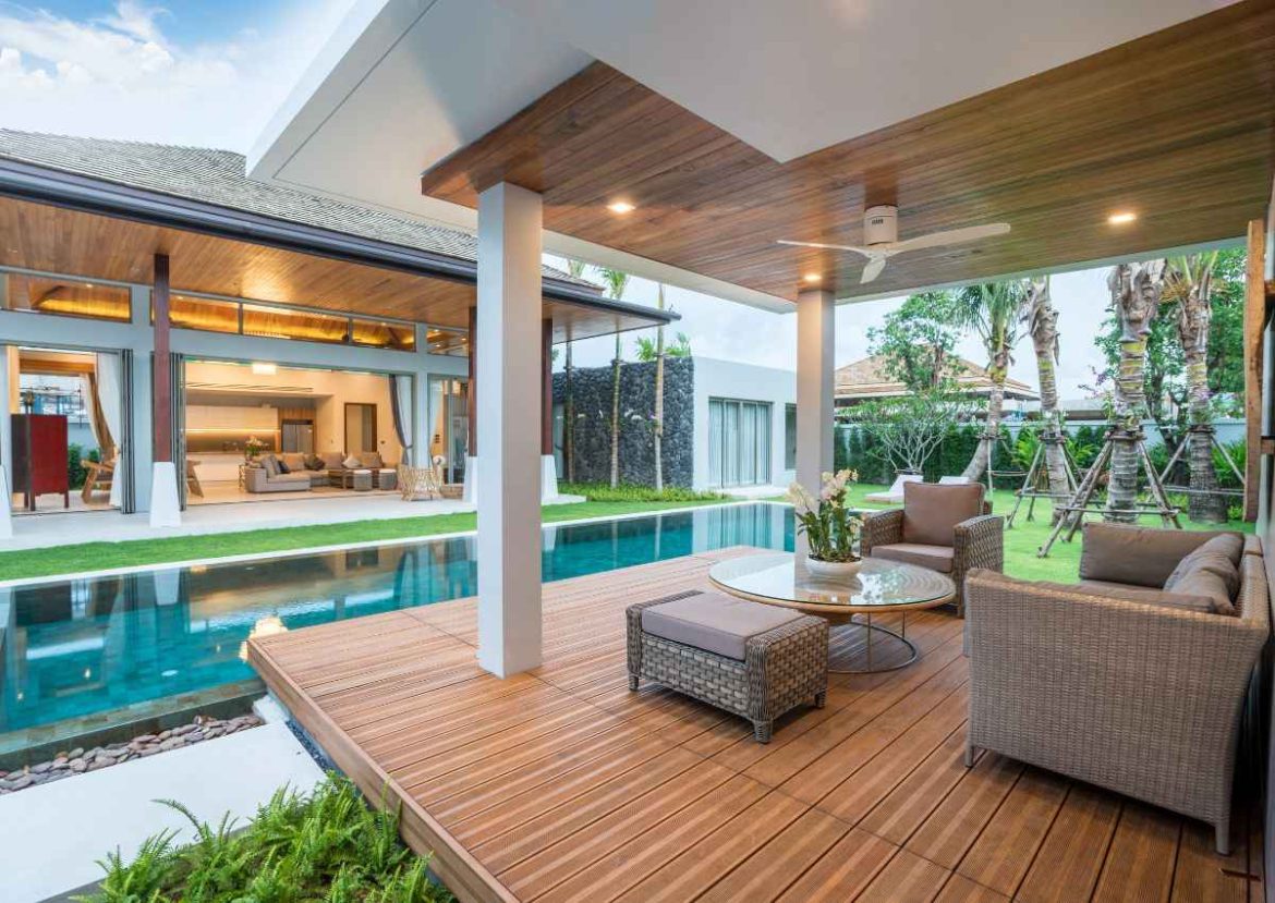 Terrasse extérieure de luxe avec piscine, plancher en bois composite et plafond en menuiserie sur mesure.