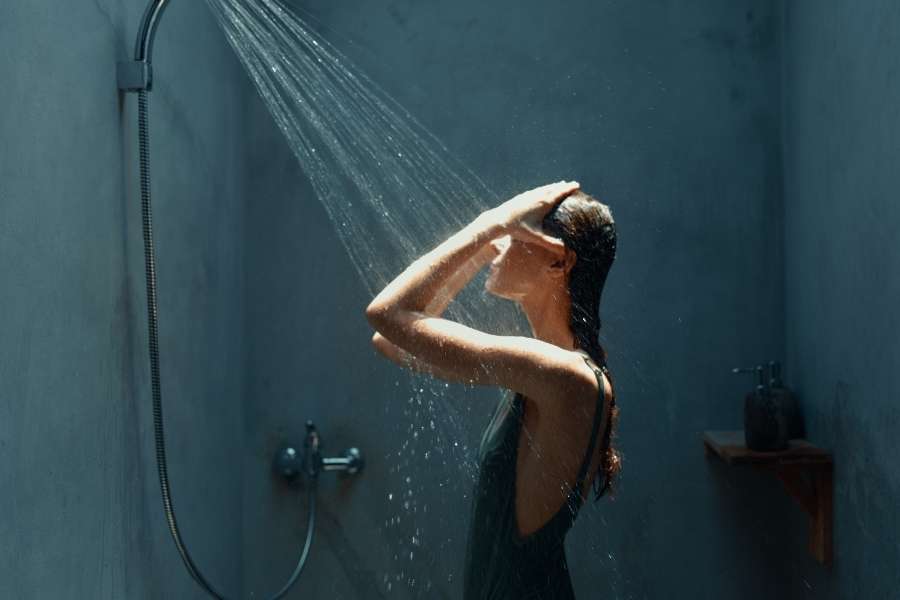 Femme sous la douche moderne avec jet d’eau relaxant, ambiance bien-être douche ou baignoire
