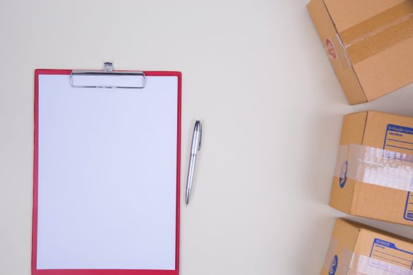 Carton de déménagement avec un bloc-notes et un stylo pour réussir son déménagement en Martinique